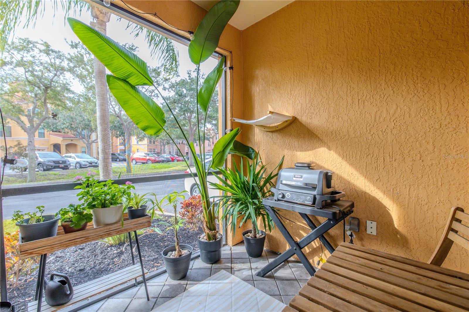 Private, covered patio ideal for morning coffee or evening grilling, framed by tropical greenery and offering a cozy outdoor retreat just off the living space.