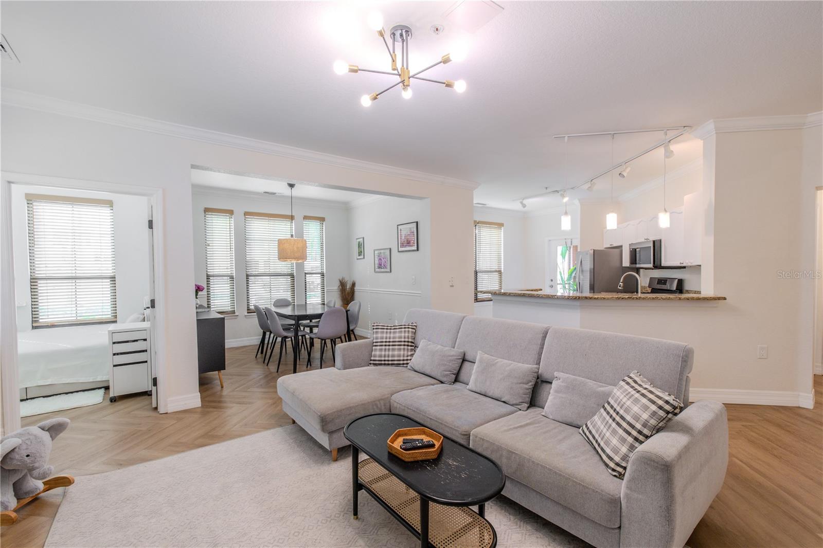 The living room’s open-concept design add a seamless connection to the dining area and kitchen beyond.