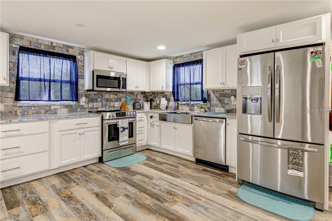 kitchen with granite countertop and matched tile back splash and all stainless-steel
