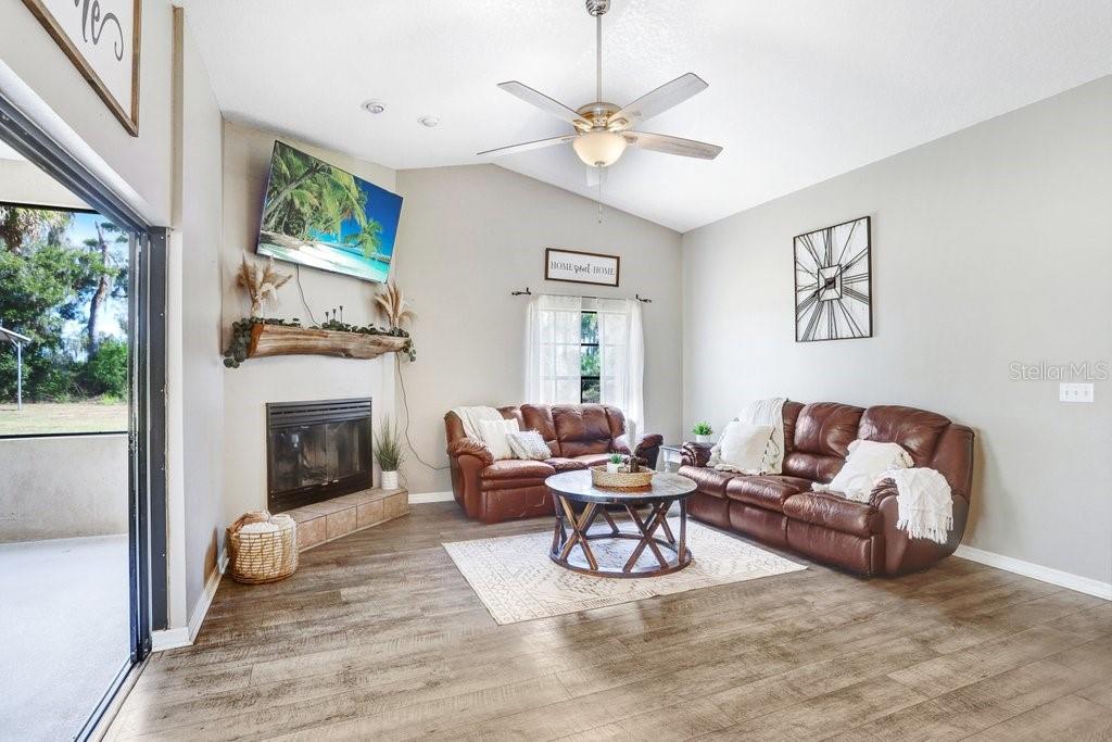 Living Area with beautiful mantel, wood burning fireplace and pocket sliders to the lanai