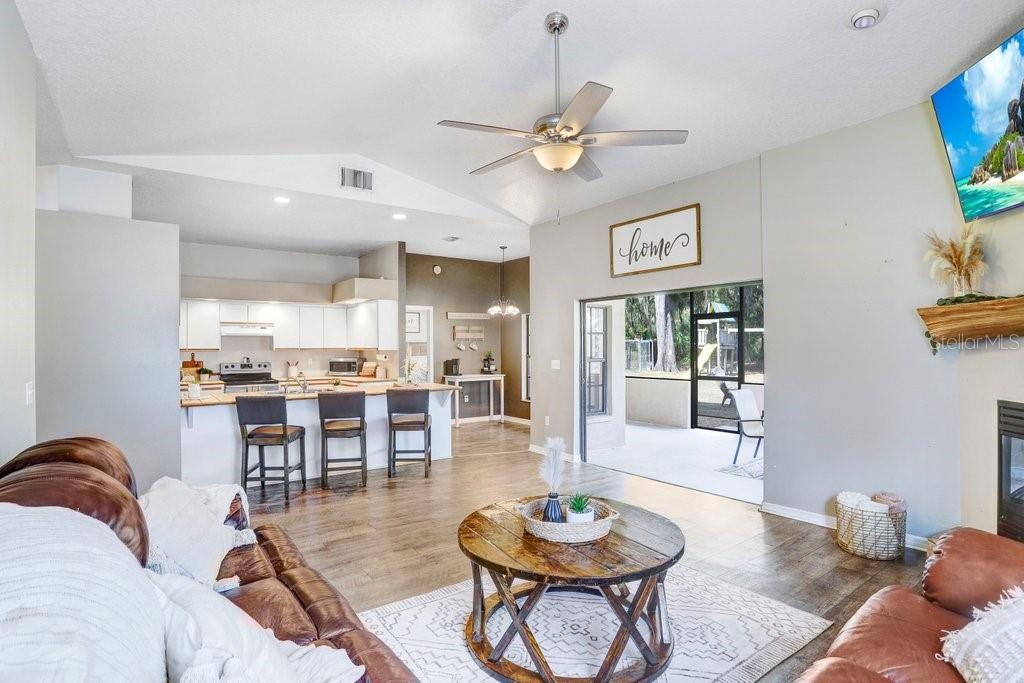 Living Area with beautiful mantel, wood burning fireplace and pocket sliders to the lanai