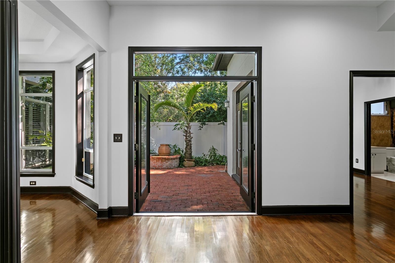 Entertaining is effortless with double doors that open to the brick pavered courtyard.