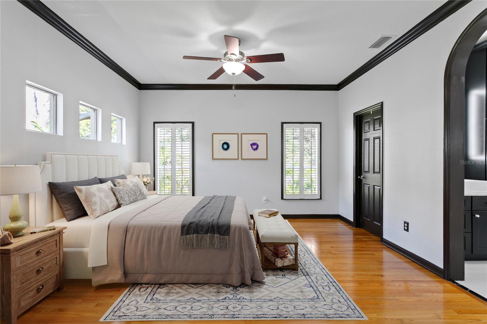 This serene primary suite features stunning hardwood floors and a large walk-in closet.