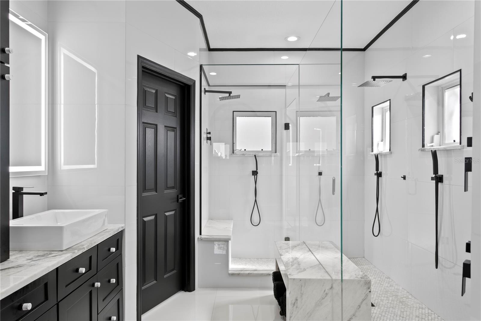 The spa-inspired primary bathroom boasts an expansive shower with multiple shower heads and luxurious finishes for a true retreat experience.
