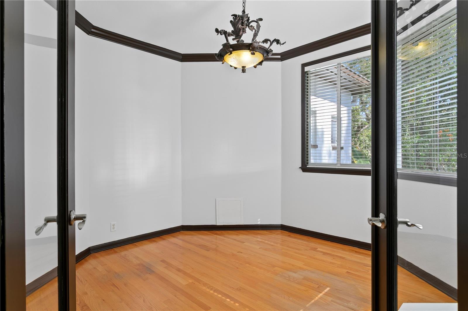 Upstairs, the sunlit bonus room features glass double doors and expansive windows.