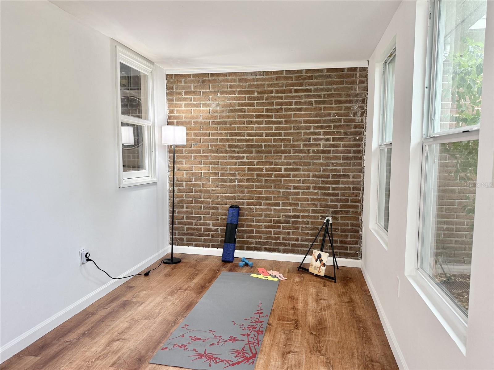 Florida Room - Brick Accent Wall and Door to Side Yard.