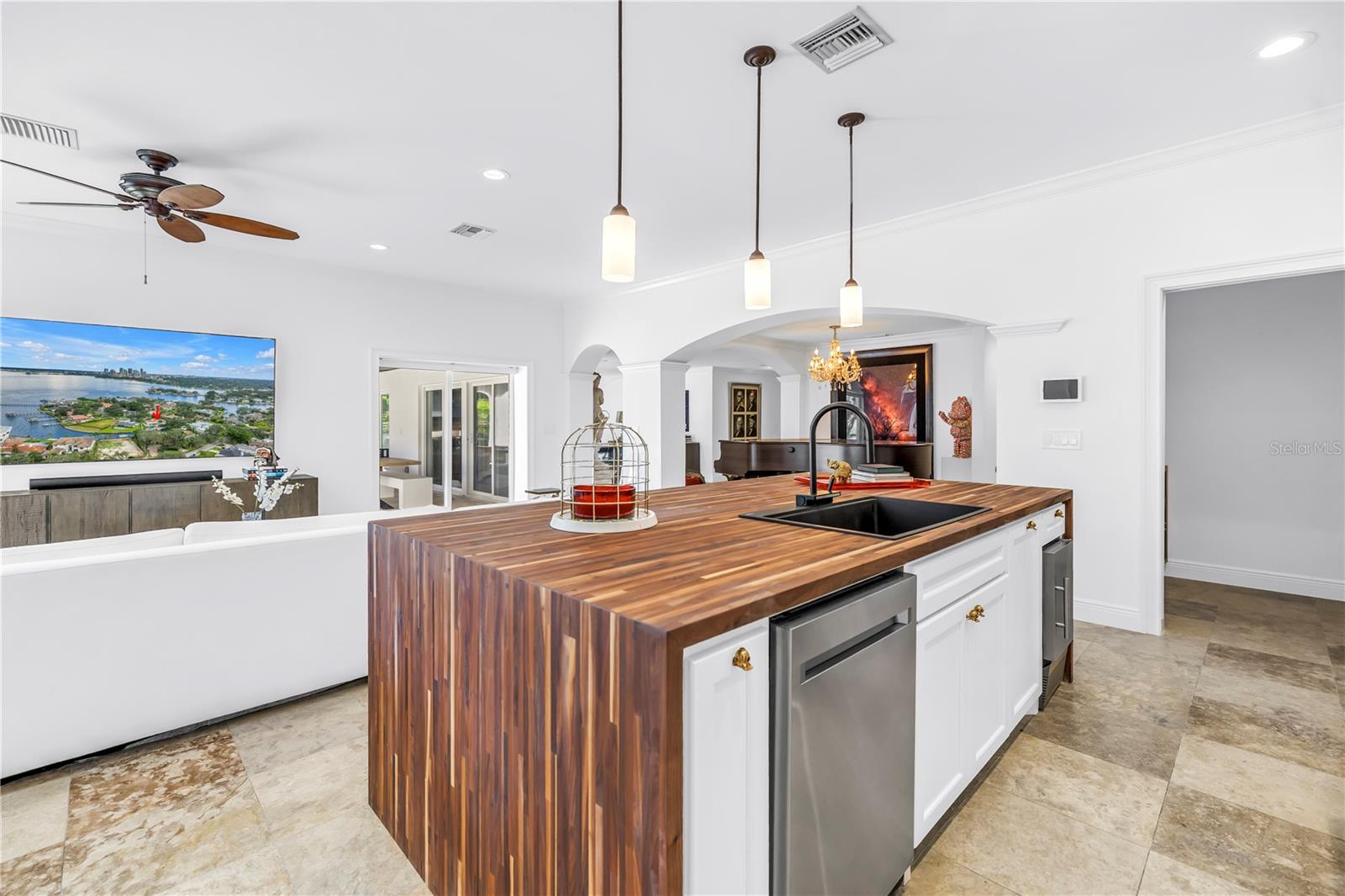 Butcher block island houses dishwasher, sink and ice maker