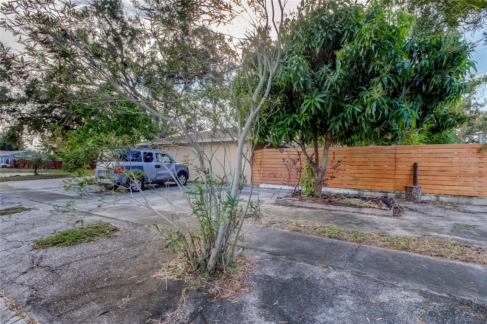 NW view of house with lots of parking space, and fence area, around back yard. Vehicle will be removed.
