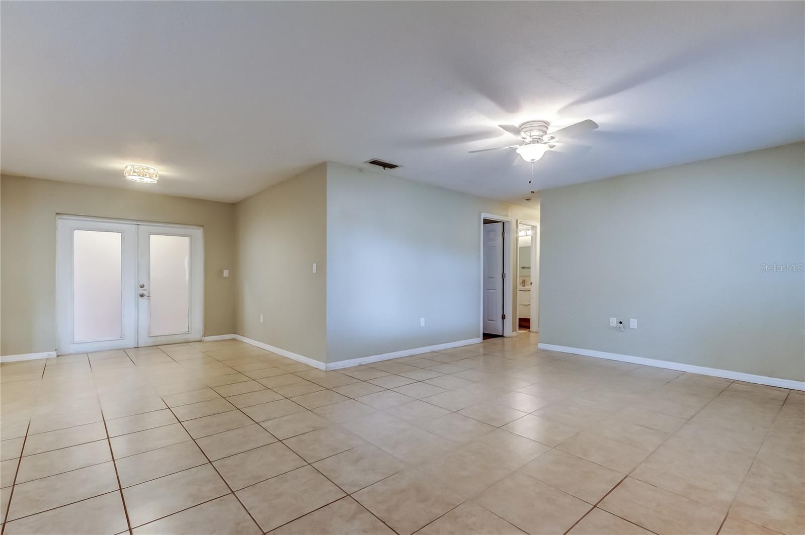 Living/dining room. French doors leading out to bonus room and screened porch.