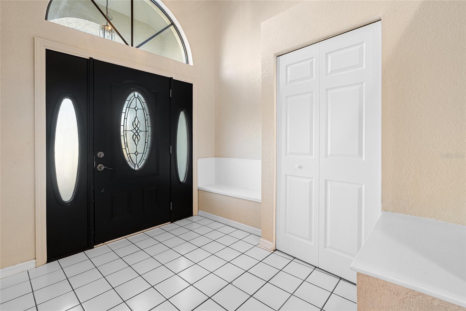 Front entry of home with bench and closet!