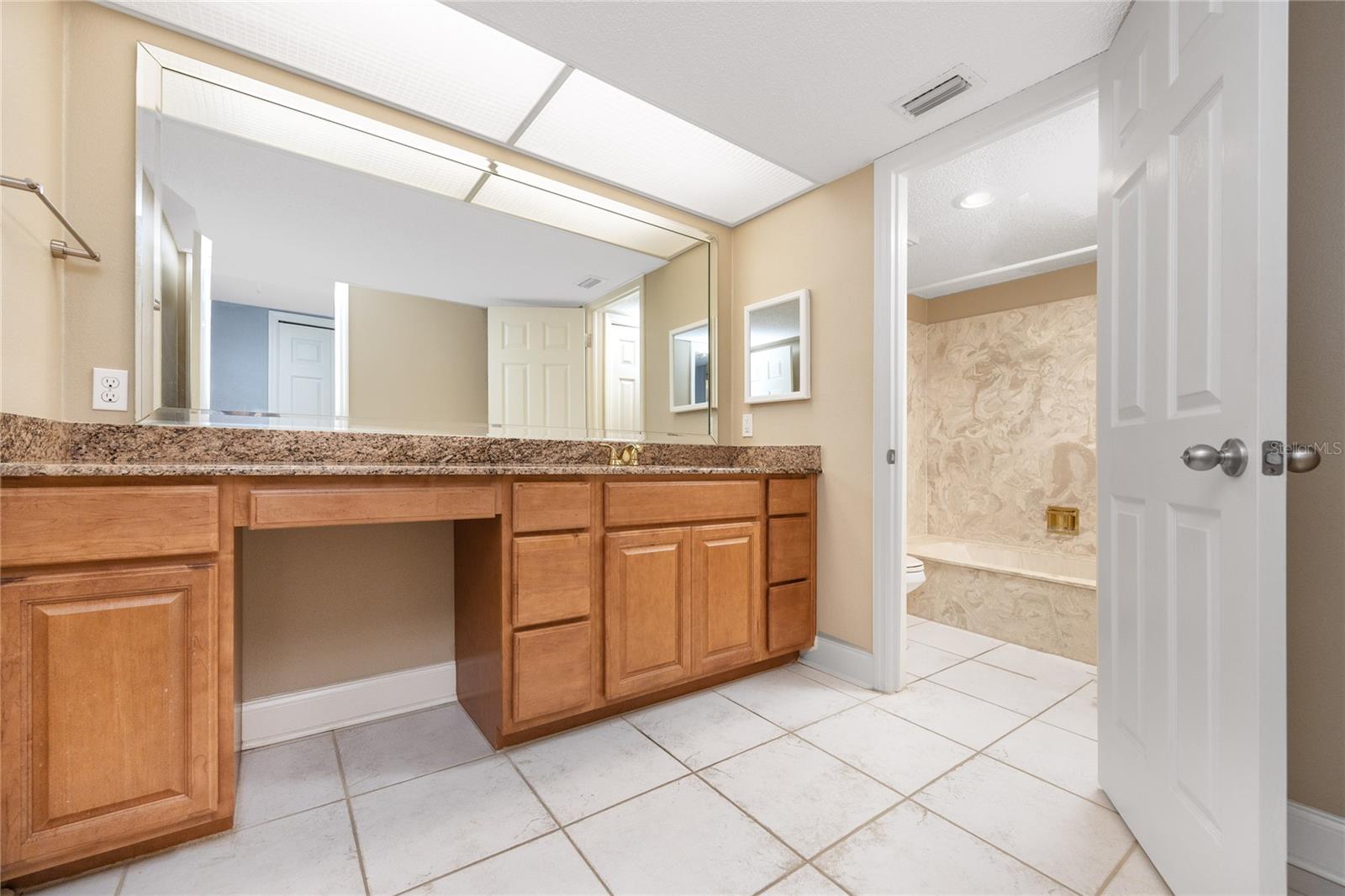 Primary en-suite bathroom with tub and built in vanity.