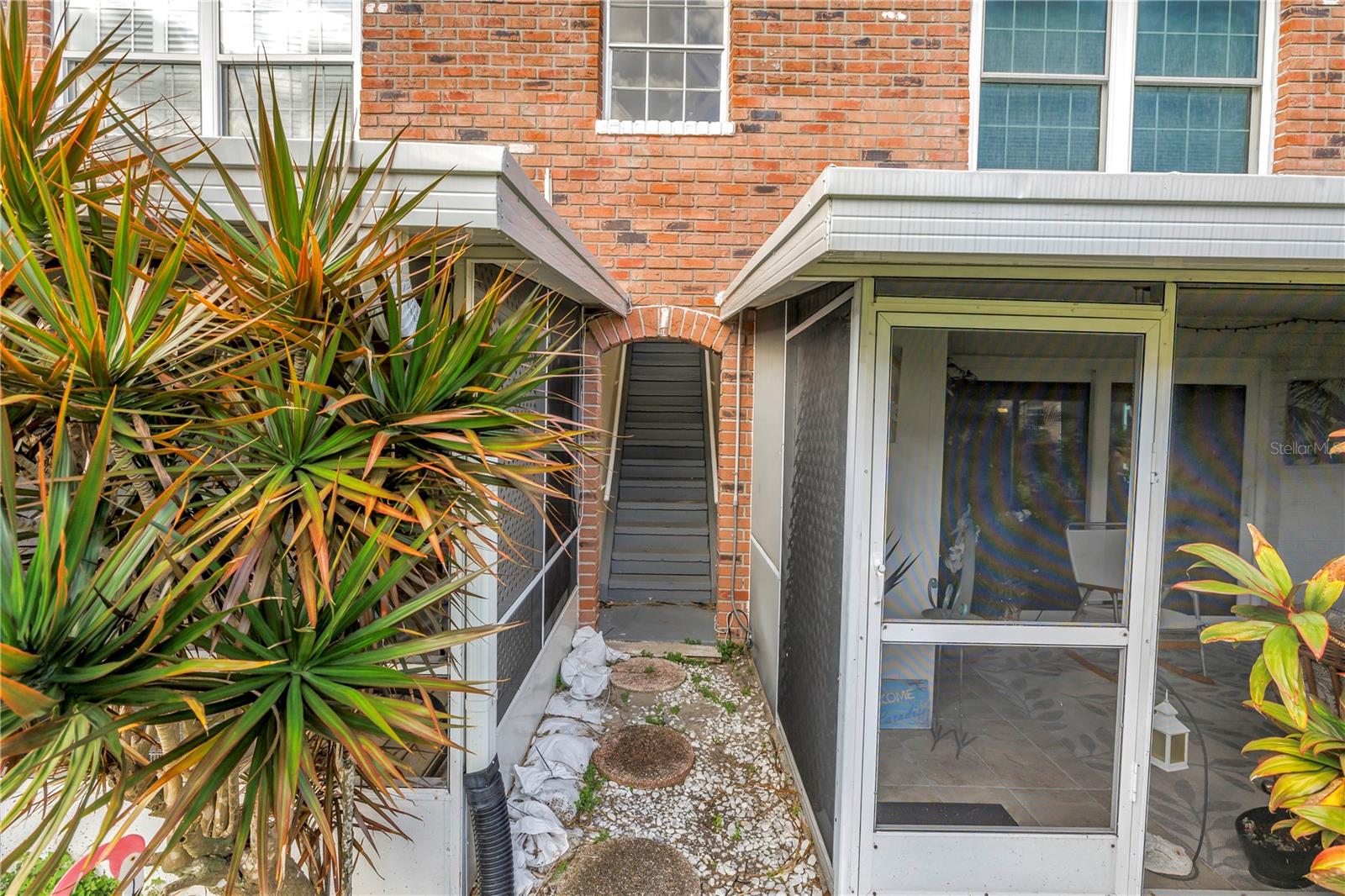 Entryway to second-floor back door and ground-floor screened lanai