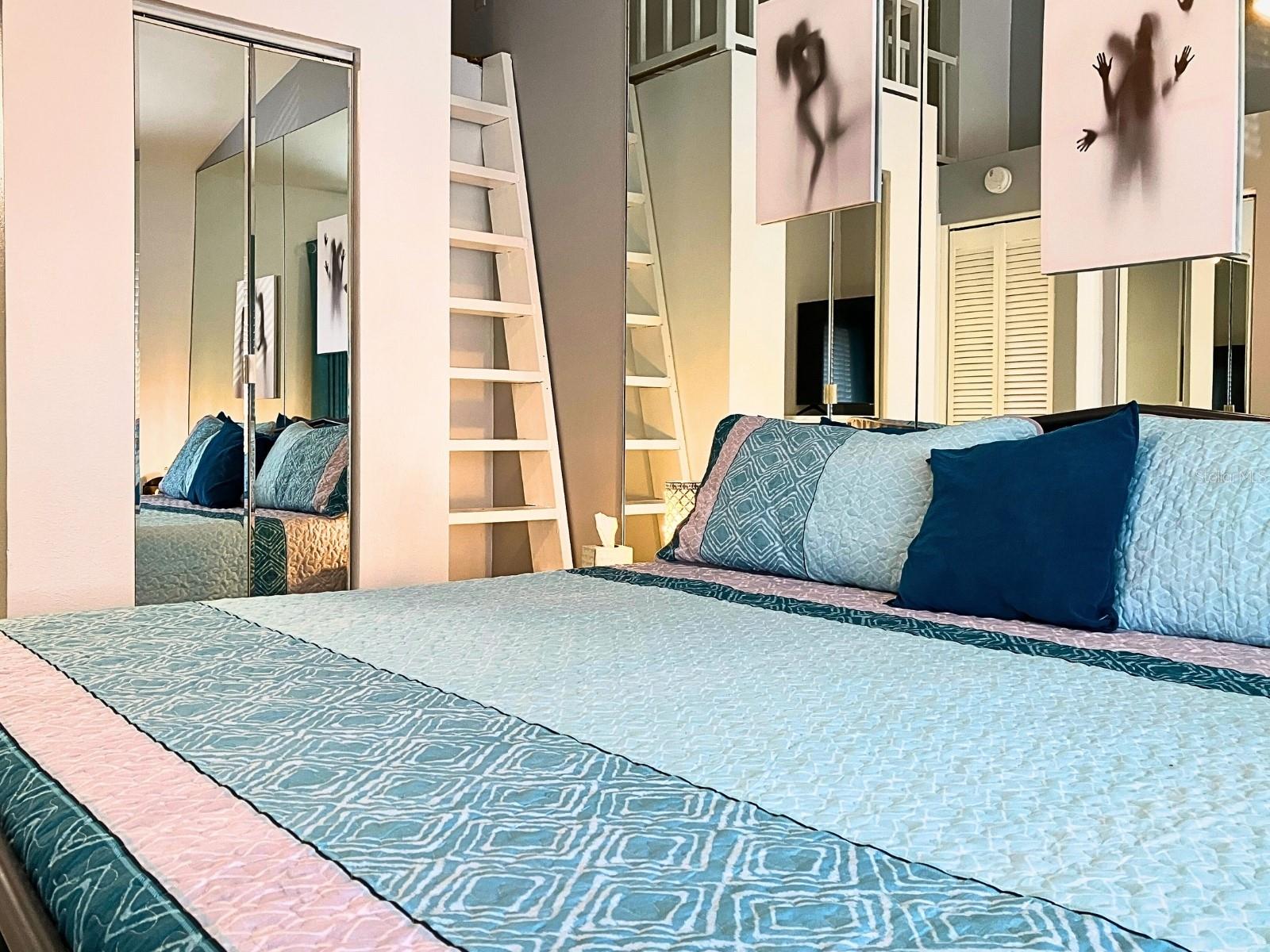 Large bed with stairs to the loft space