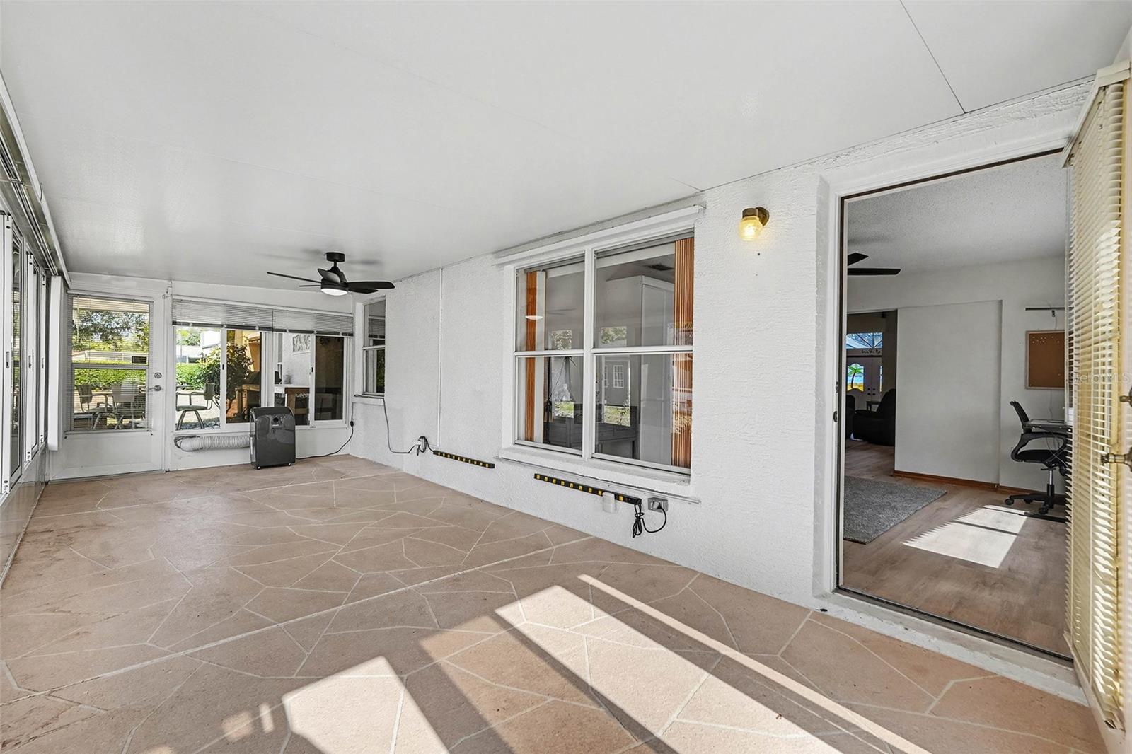 Patio with windows and door leading to den/flex space