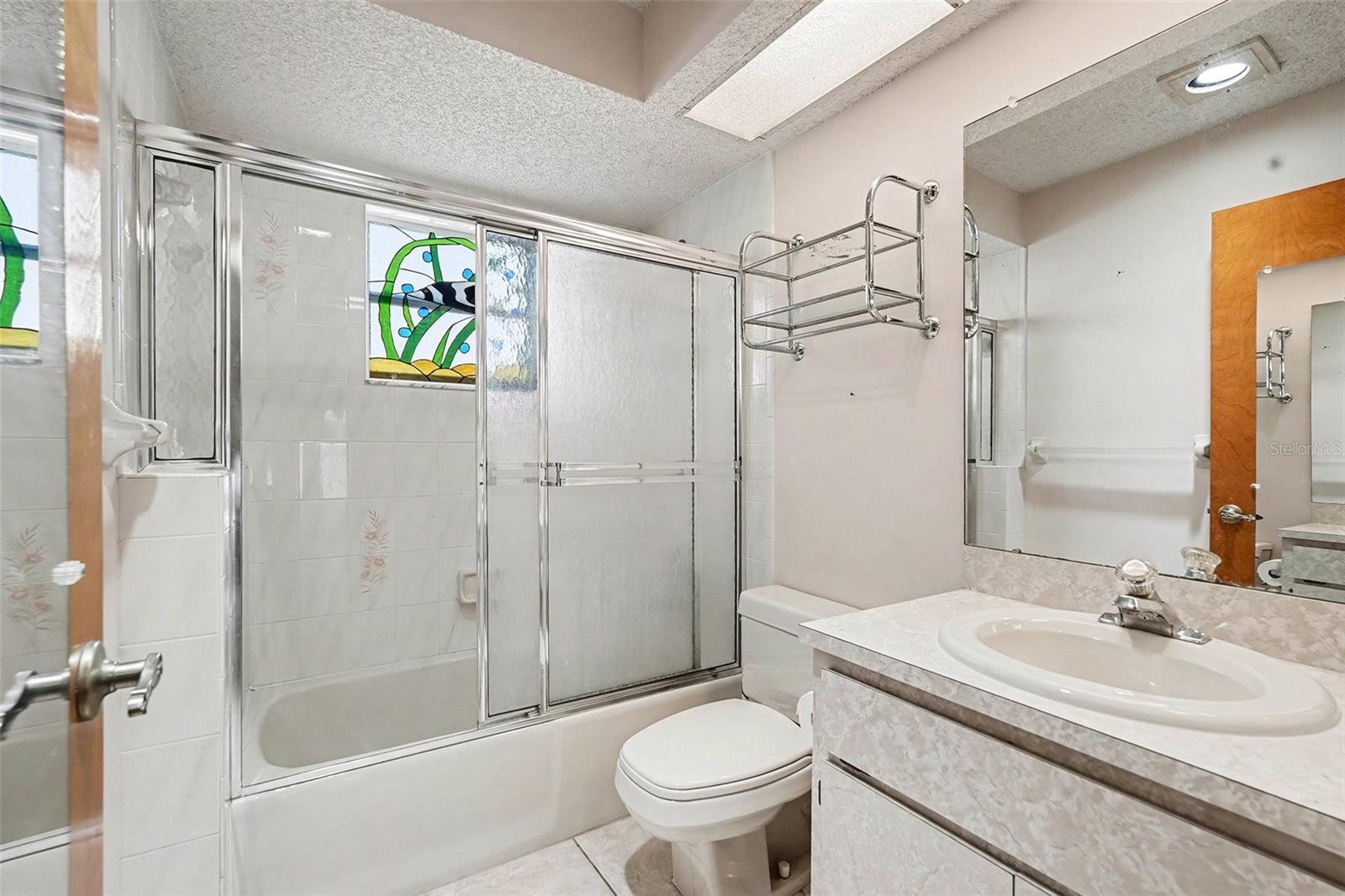 Bathroom 2 with custom stained glass window, shower bath combo
