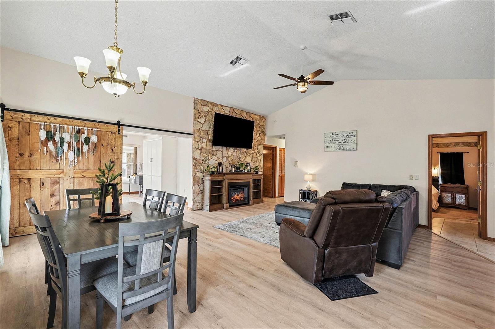 Dining room view overlooking the living room, barn door leading to den/flex space