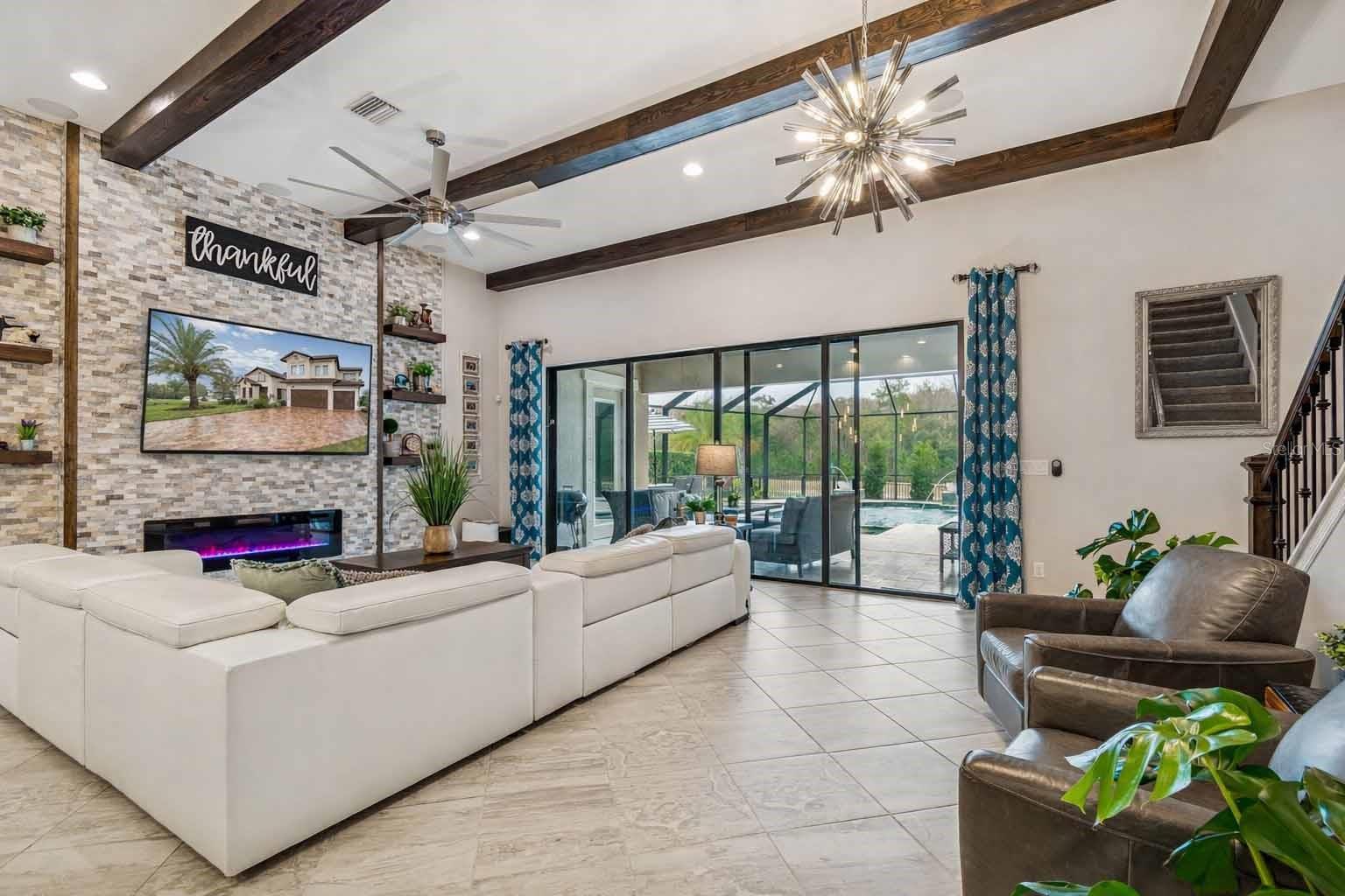 ENJOY THE UPGRADED GRAND ROOM ACCENT WALLS & BEAMS IN A LUXURIOUS OPEN PLAN & EXQUISITE POOL VIEWS