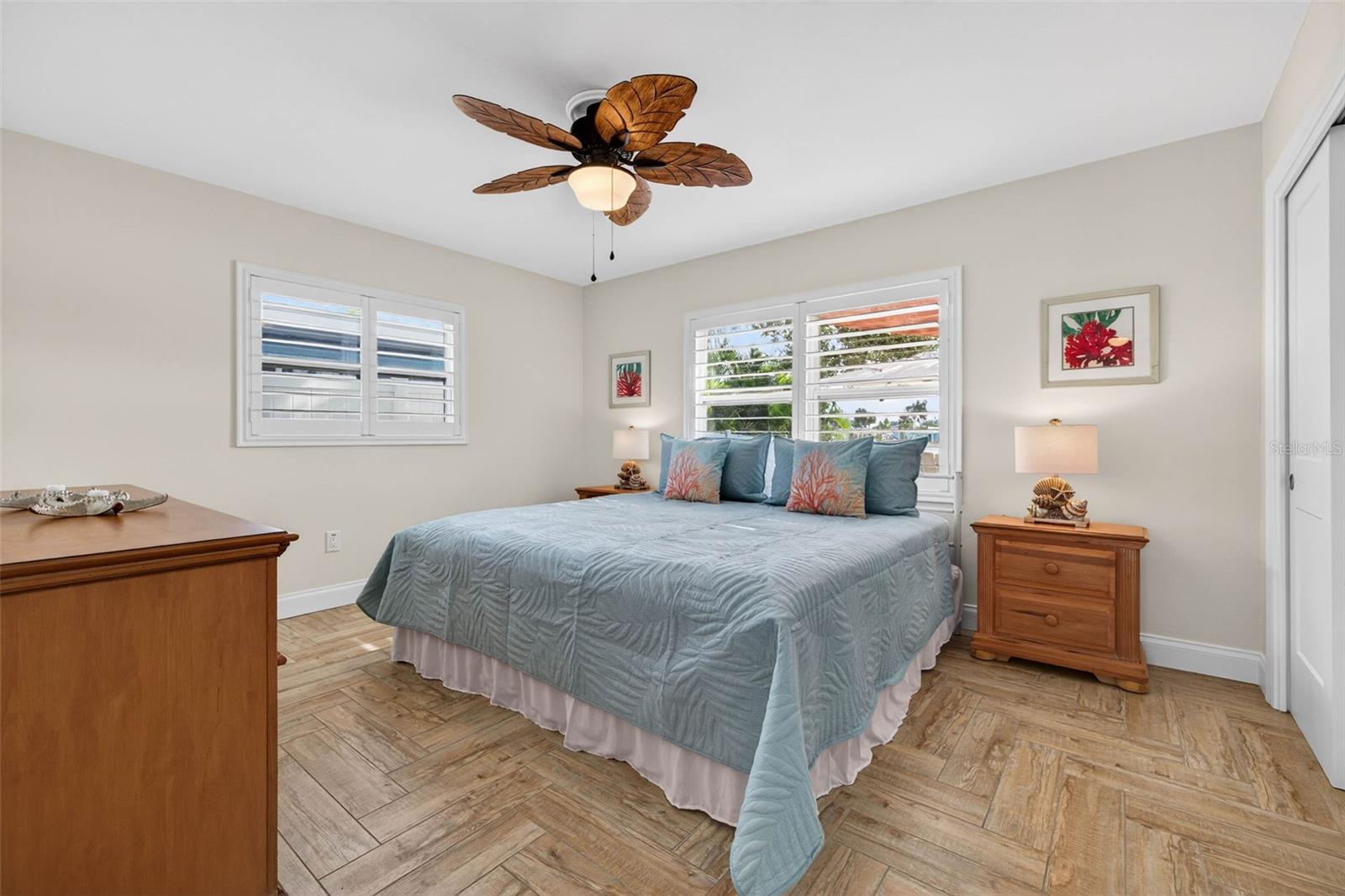 Master bedroom with wood-look tile, neutral paint colors and two closets