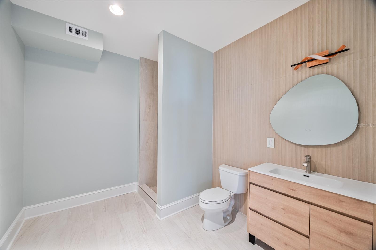 Newly renovated full bath located in the downstairs bonus room.