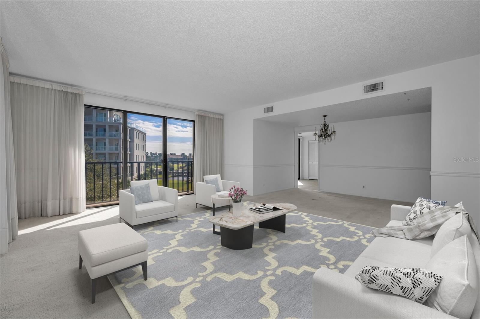 Huge living room with one of the dining room options under the chandelier.
