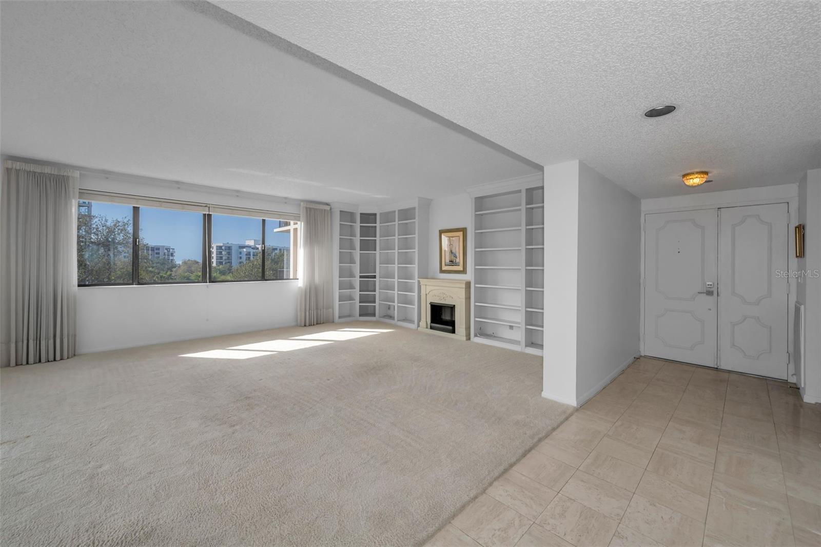 The family room without staging, has a fireplace feature (not wood burning or heat generating), and lots of built in book cases. Keep them white, add depth and/or color as you choose!
