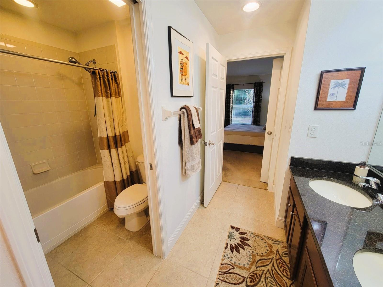 Convenient Jack-and-Jill bathroom with dual access, tub/shower combo, and updated vanity—ideal for shared living.