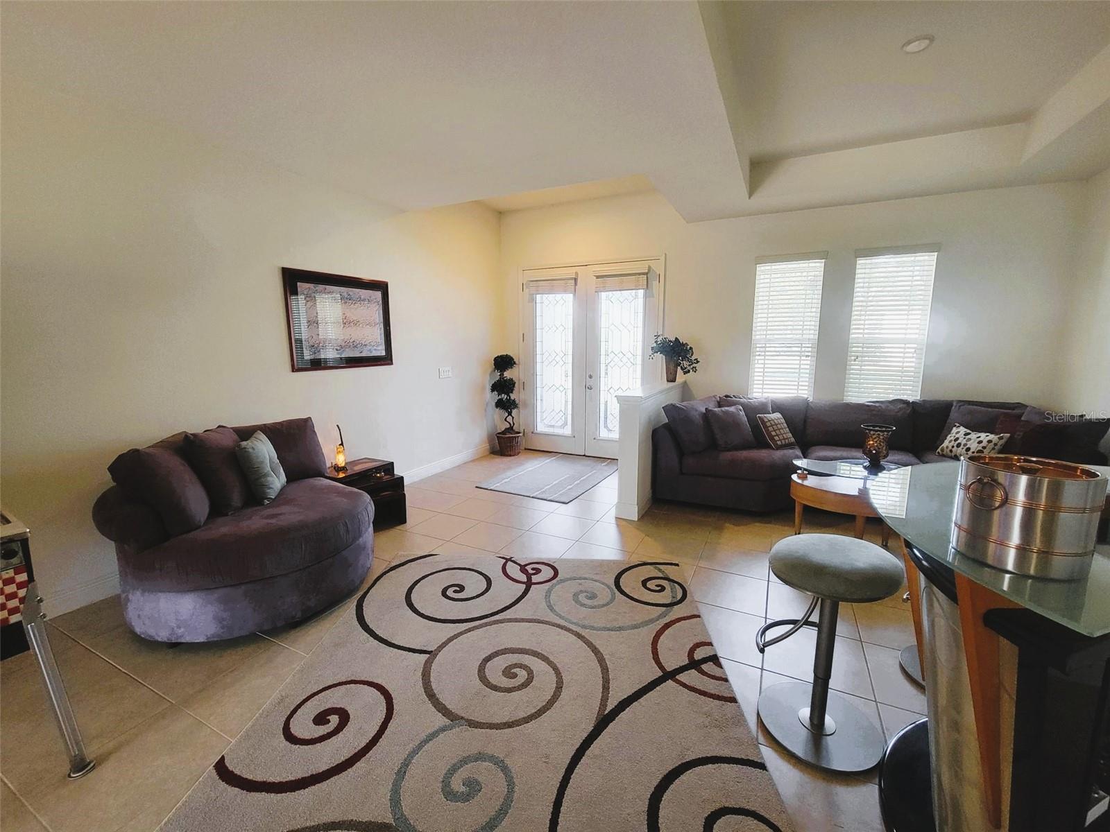 Open living and dining area with tile flooring, high ceilings, and abundant natural light—perfect for everyday living and entertaining.