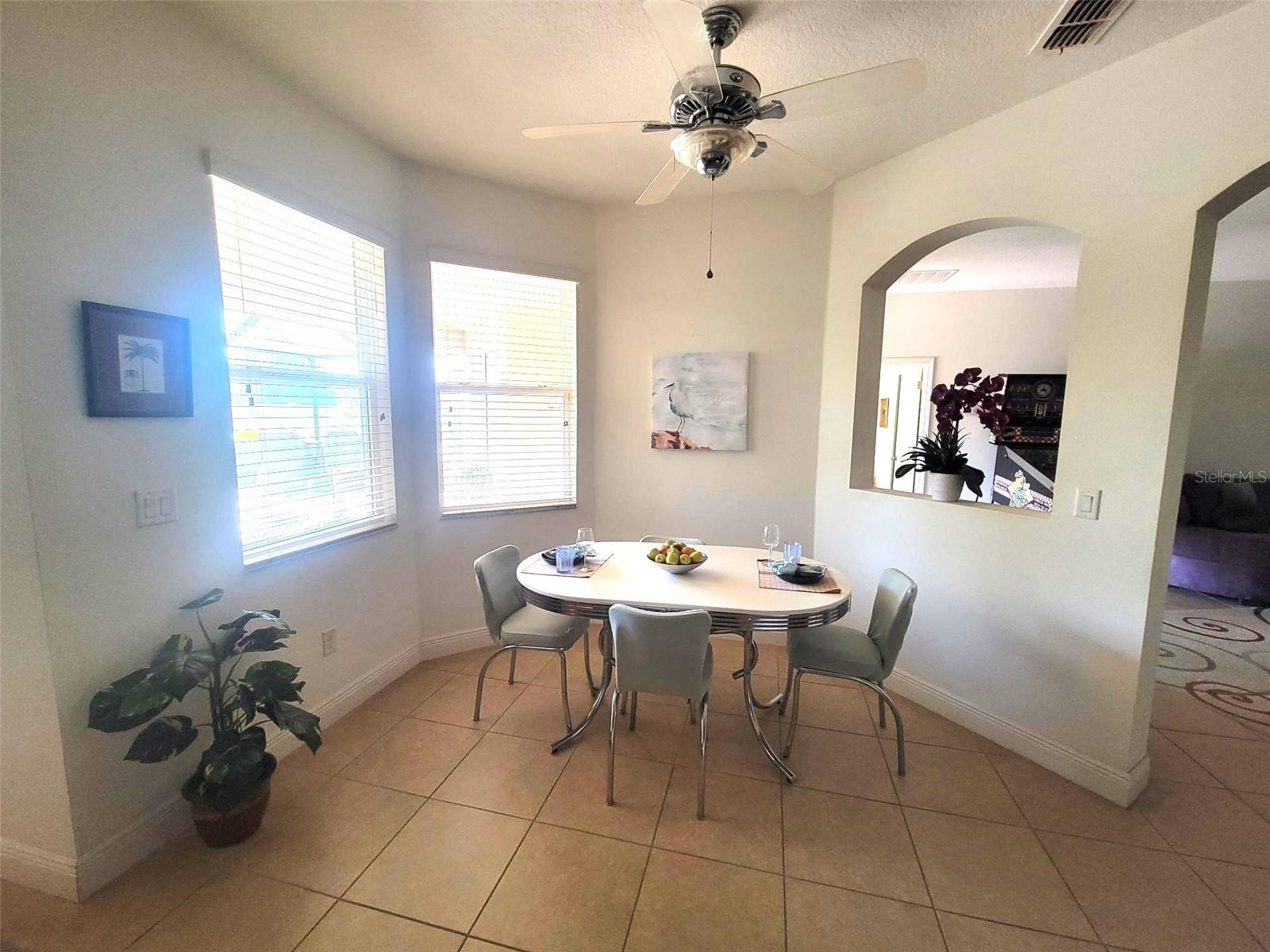 Bright kitchen nook with tile flooring, abundant natural light, and views to the private outdoor space.