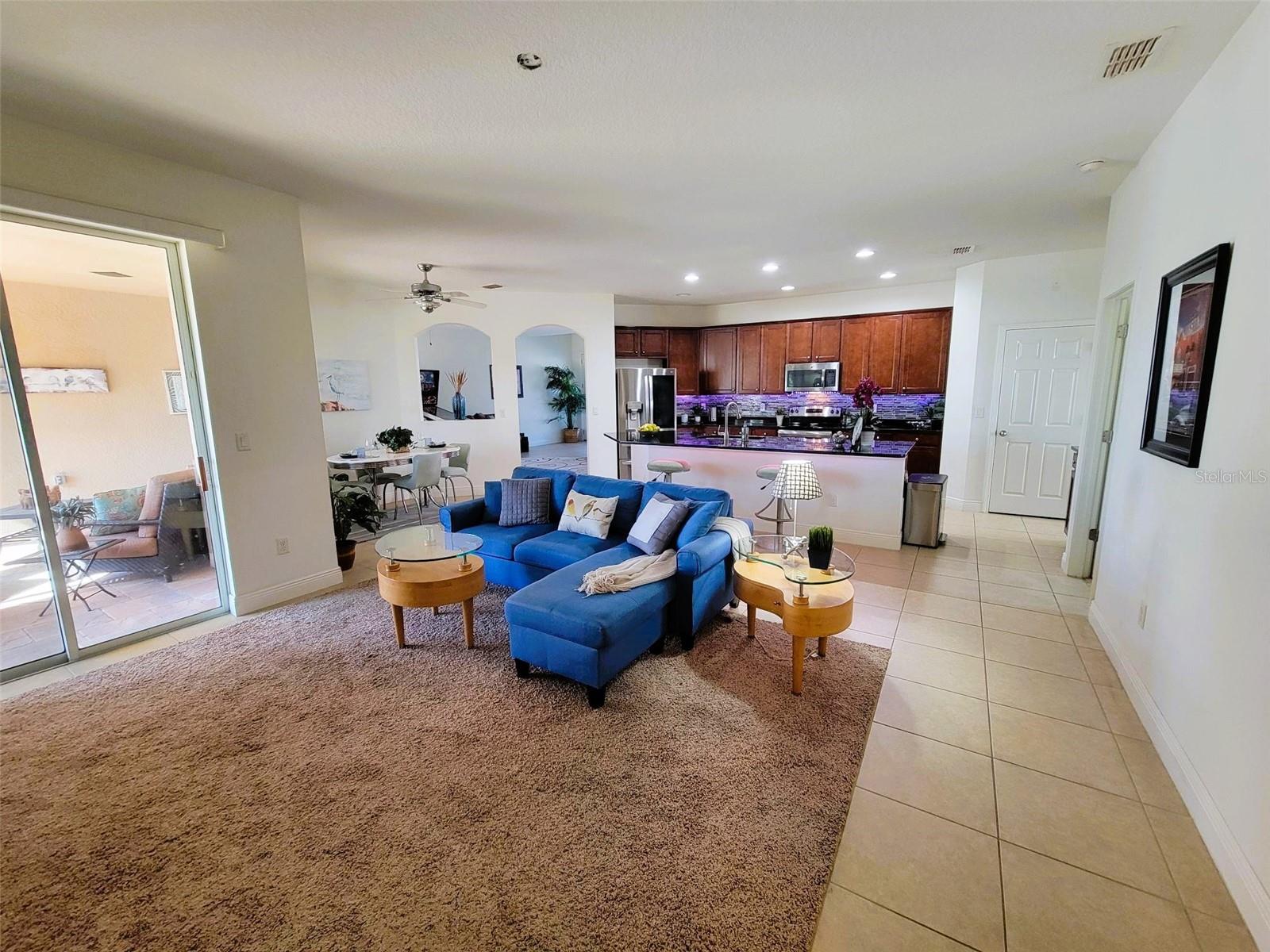 Kitchen and family room combo featuring ceramic tile flooring and sliding glass doors leading to the covered lanai.