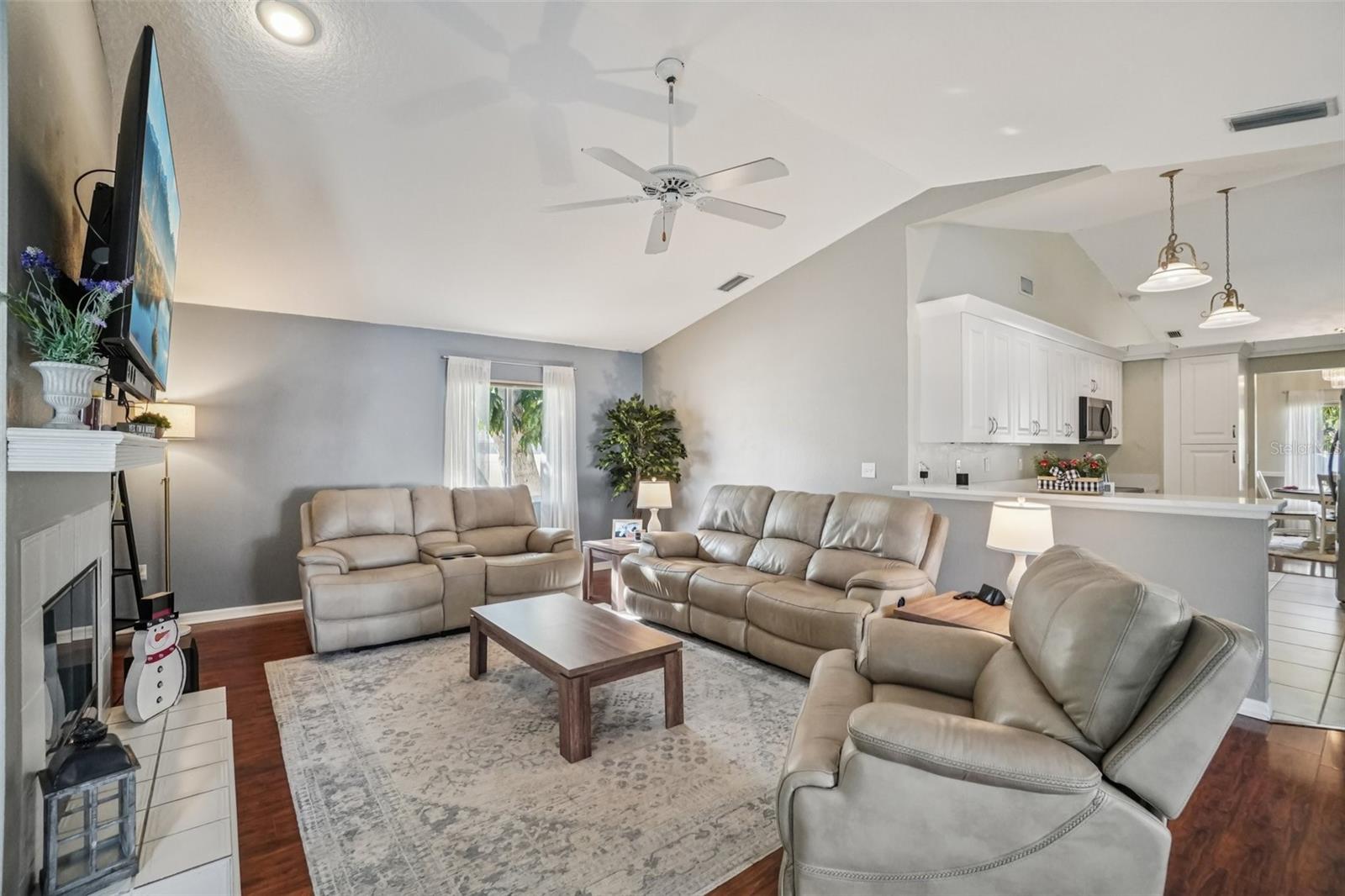Living Room (Wide View) – This spacious living room offers multiple seating areas, a ceiling fan, and an open connection to the kitchen, making it ideal for everyday living and gatherings.
