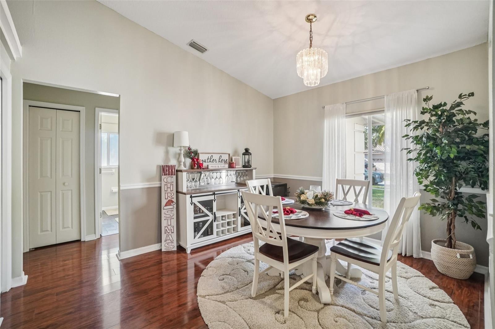 Dining Room – A bright and inviting dining room features wood flooring, chair rail detailing, and a statement chandelier, creating a welcoming space for everyday meals or special gatherings.