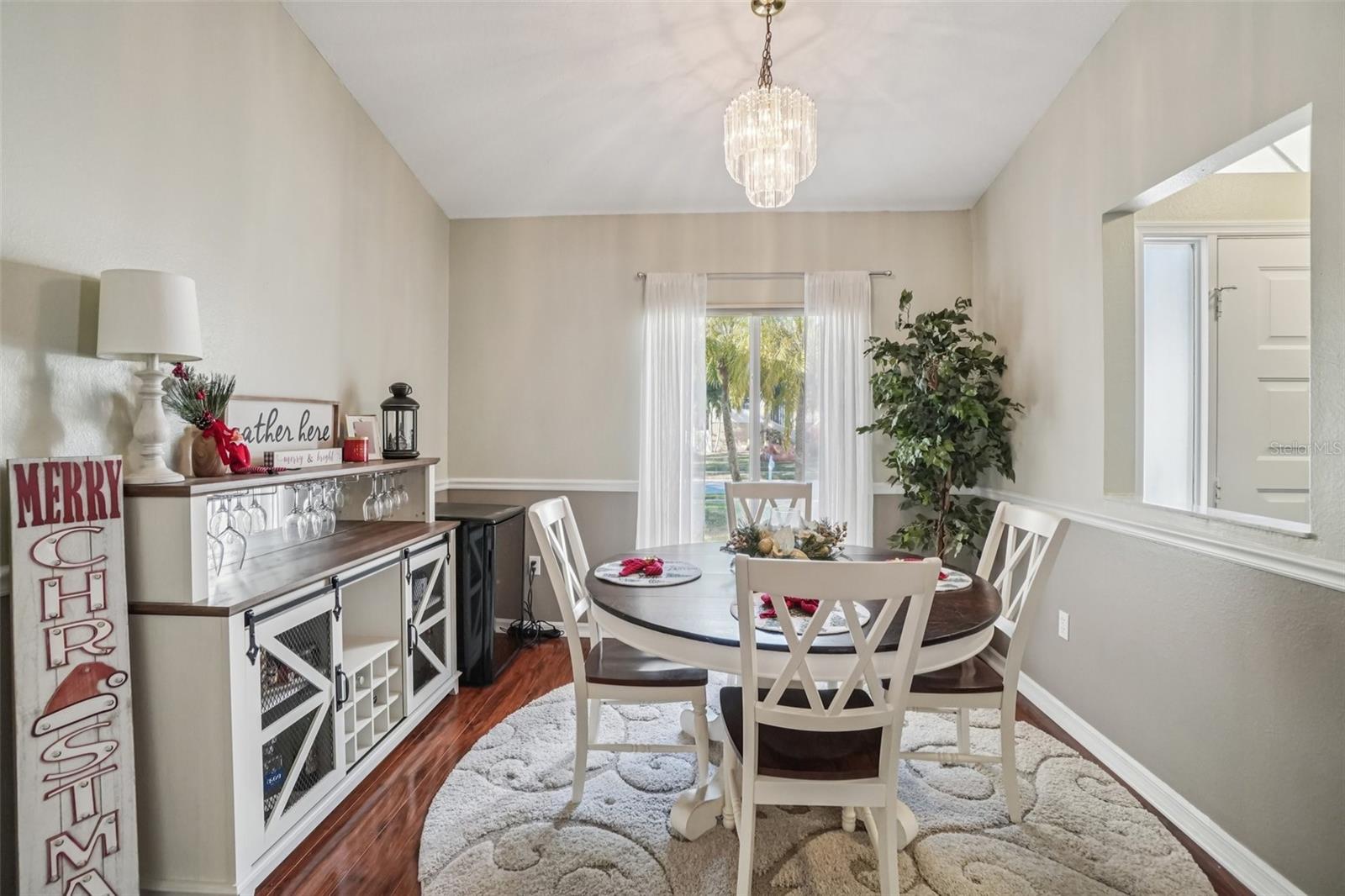 Dining Room (Alternate View) – Natural light fills the room through large windows dressed with sheer curtains, while the open layout allows easy flow to adjacent living areas.