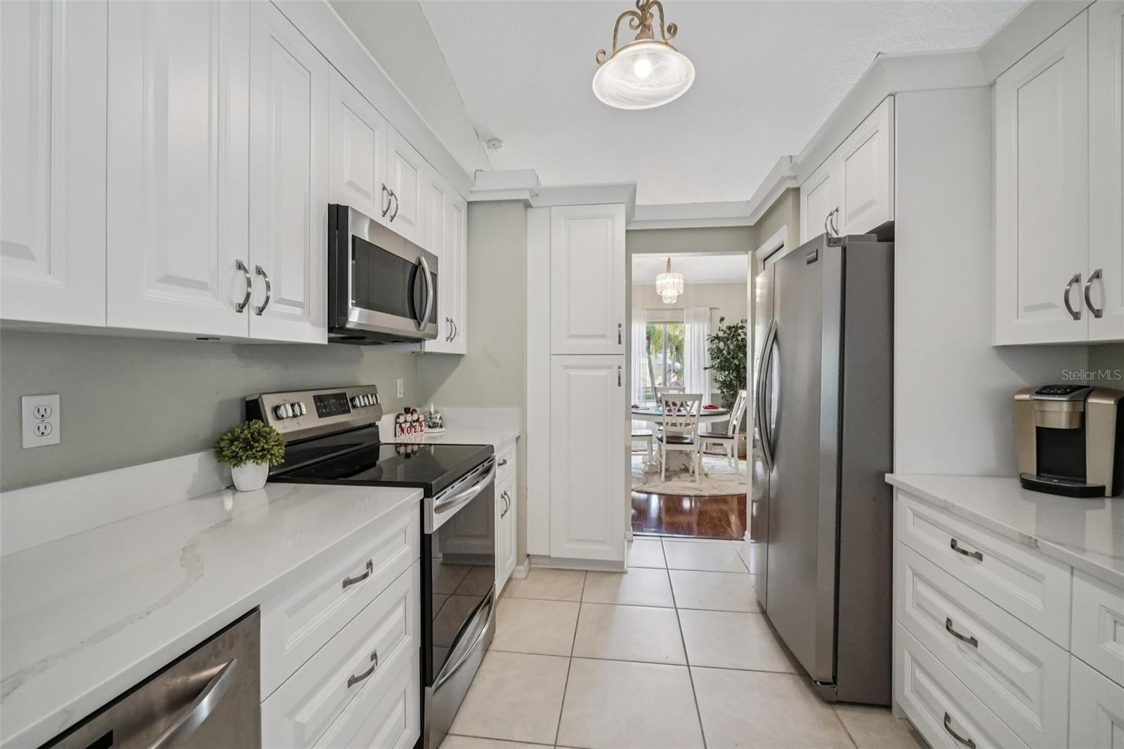 Kitchen (Galley View) – Clean lines and ample counter space define this efficient galley-style kitchen, highlighted by modern hardware, generous storage, and a well-lit work area.