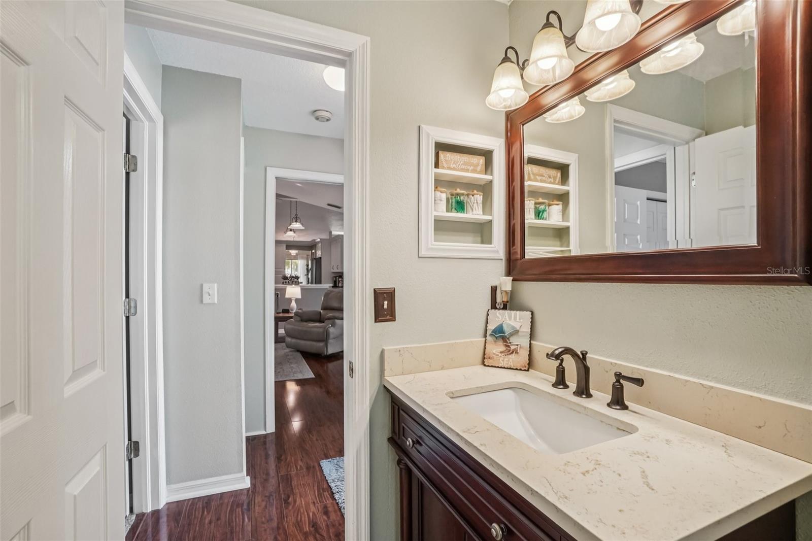 Bathroom 1 – Hall & Vanity AngleA bright and functional layout with recessed shelving, neutral wall tones, and easy access to the main living areas, offering both style and everyday convenience.