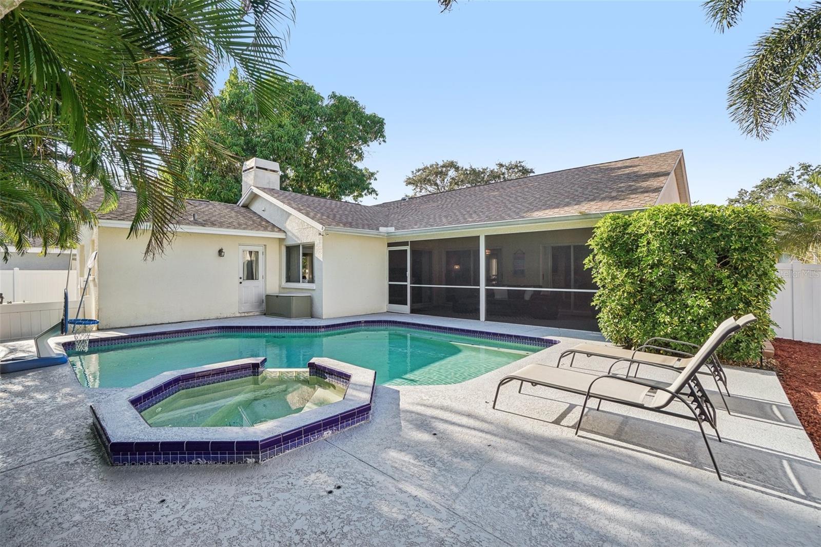 Pool, Spa & Lounge AreaResort-style backyard showcasing the pool with attached spa, sun loungers, and tropical landscaping that creates a serene, private atmosphere.