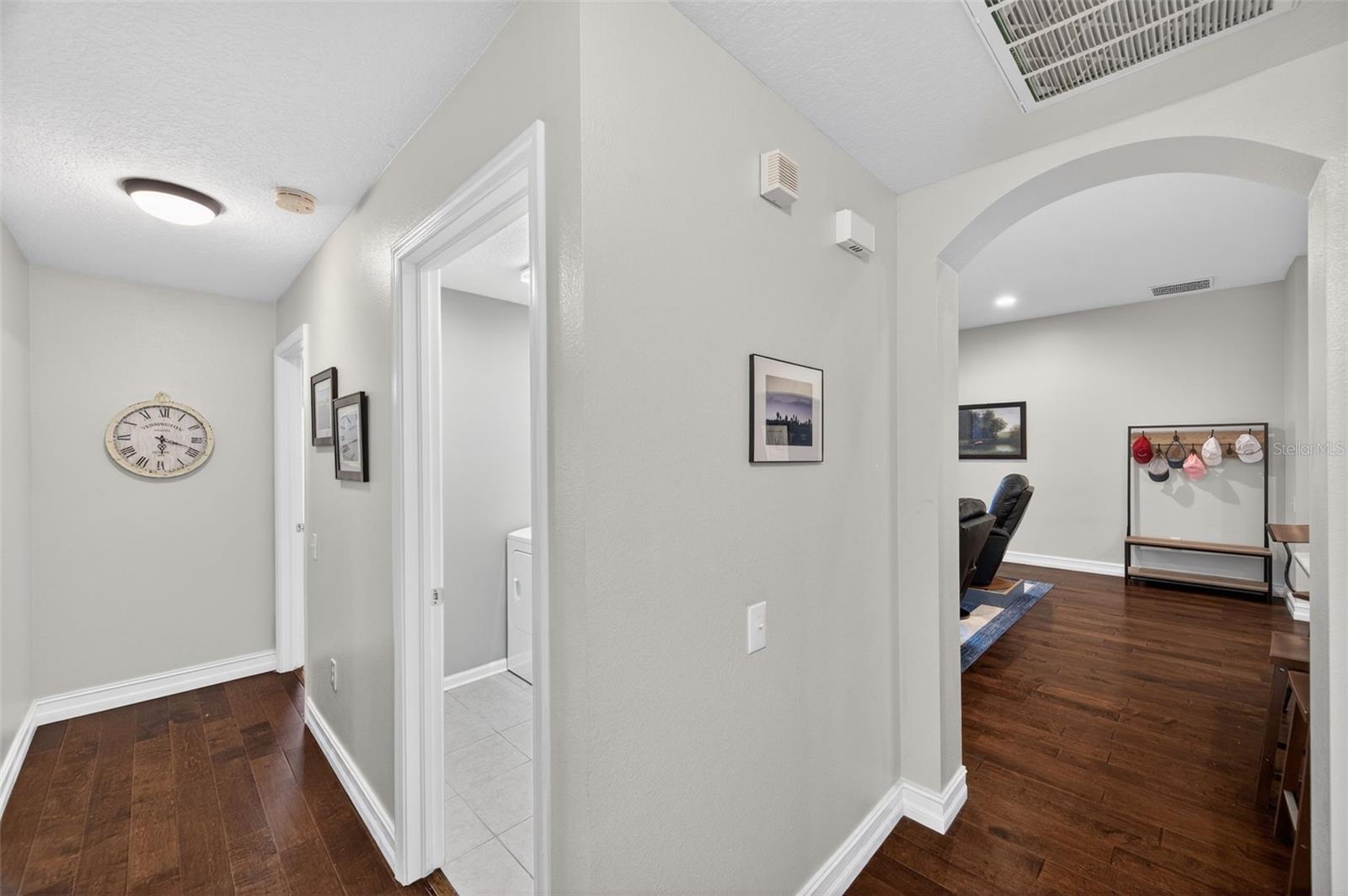 Hallway leading to bedrooms, laundry room space is pictured in the right doorway.