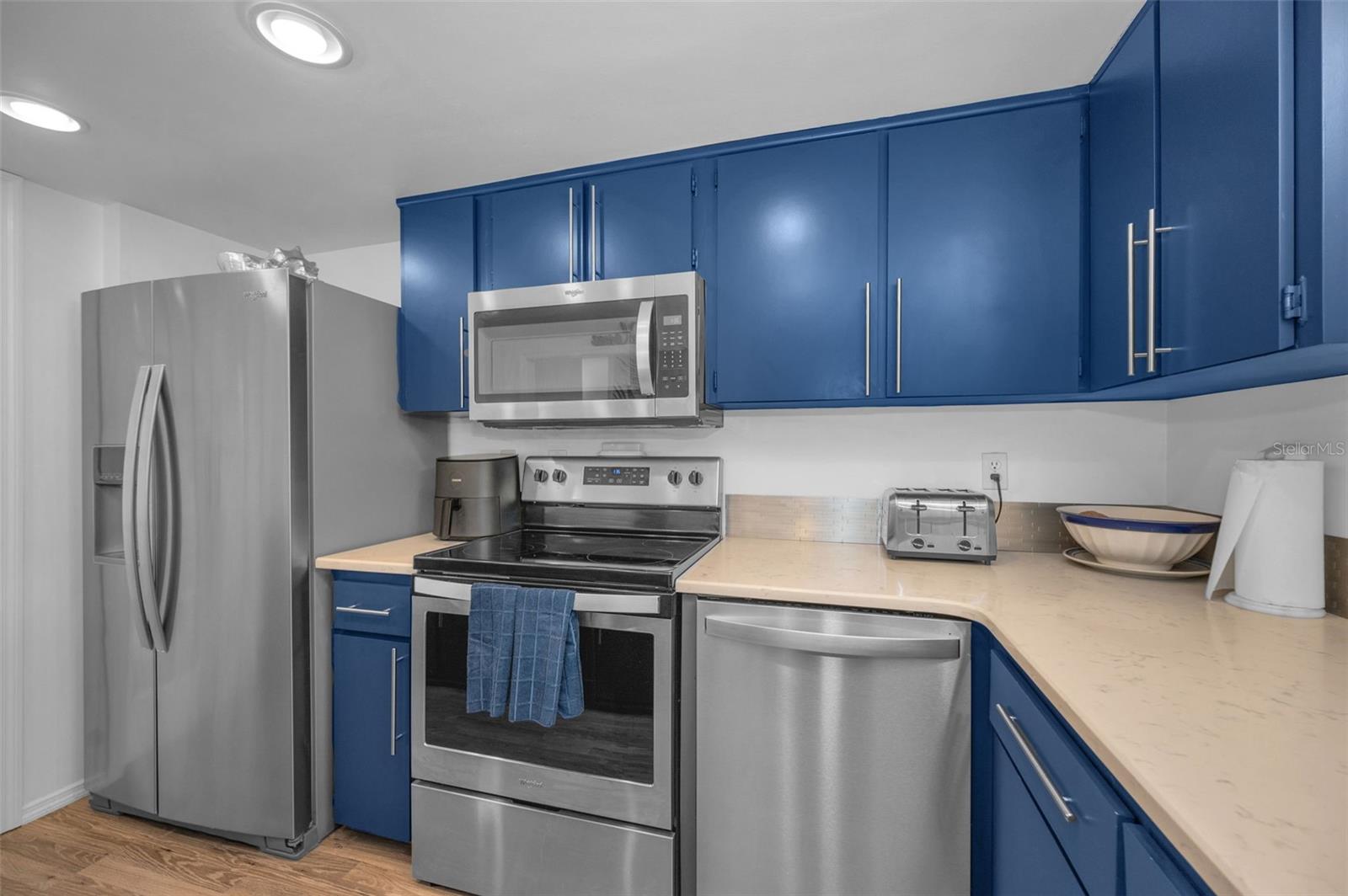 Contemporary Kitchen with offset color cabinets and solid surface countertops and backsplash