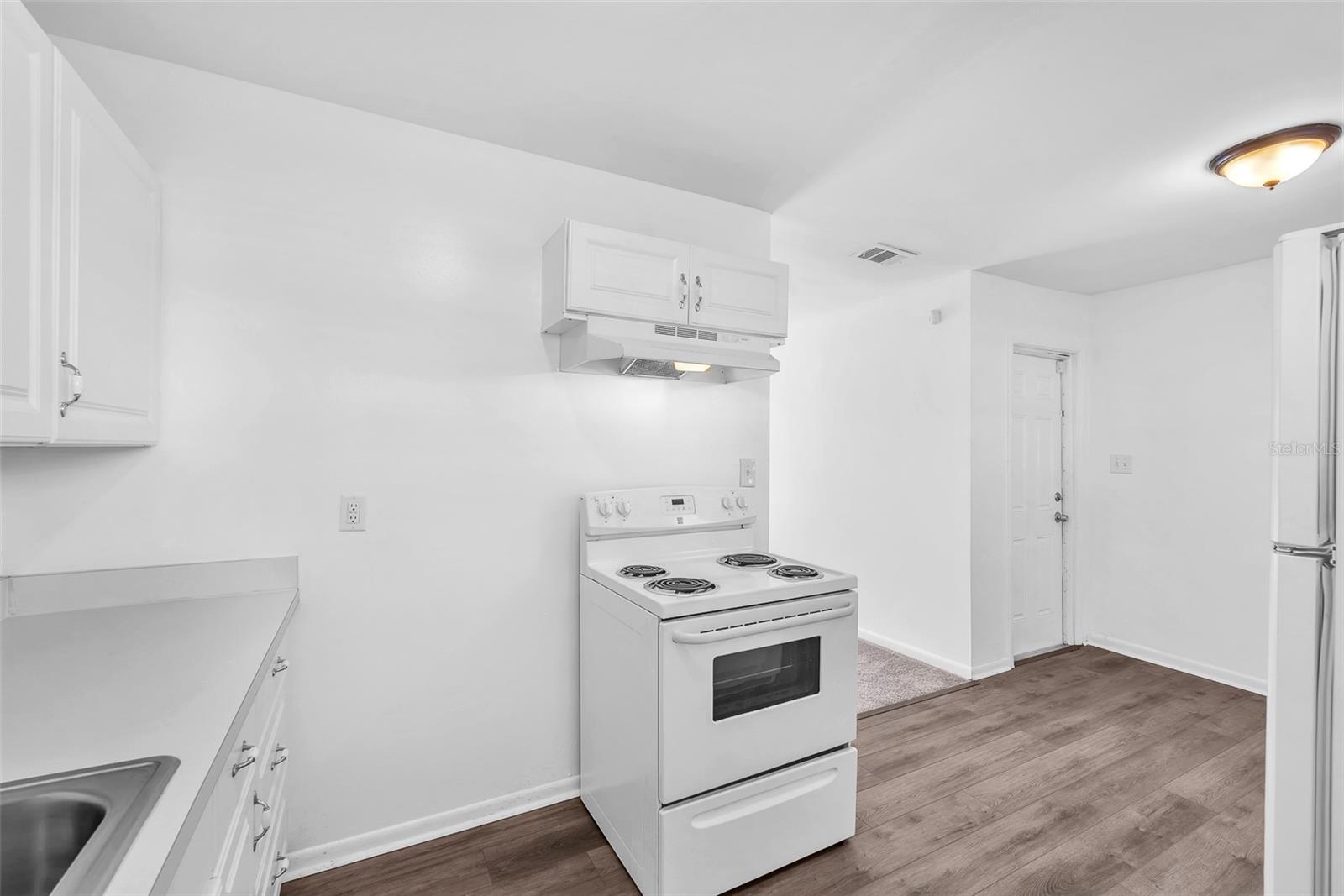 Full sized electric range with 4 burner cooktop and hood plus storage drawer below.