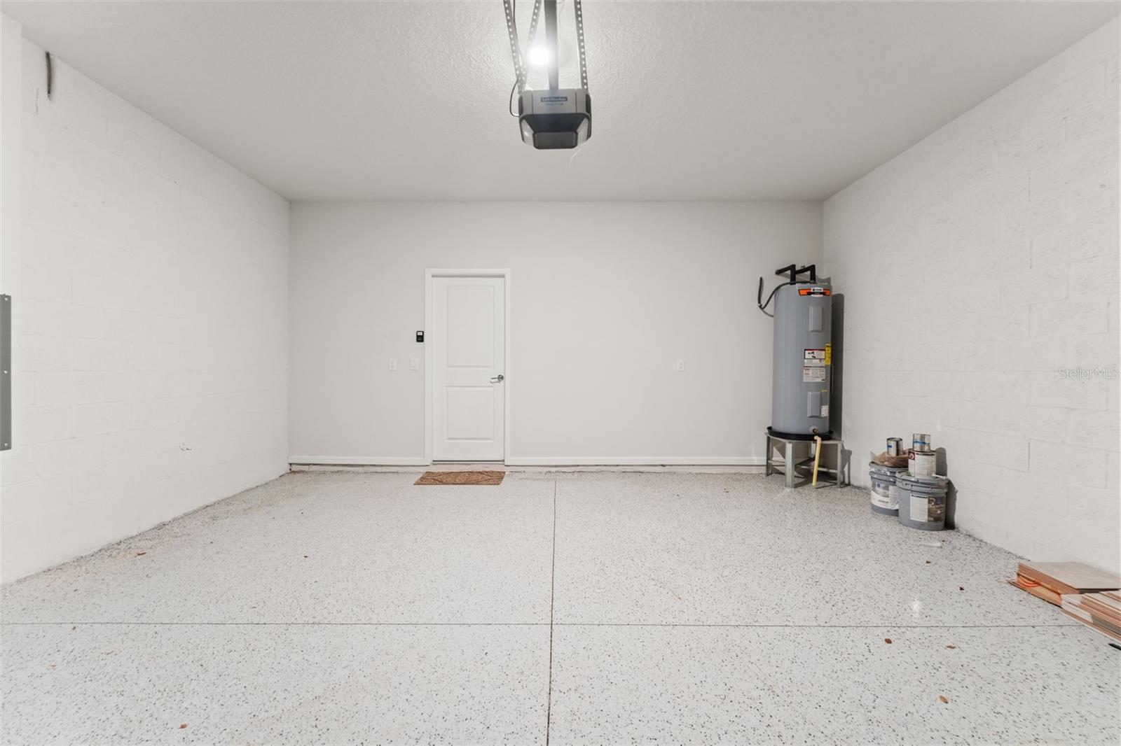 Oversized two-car garage with epoxy-style flooring, automatic garage door opener, and additional wall space for storage.