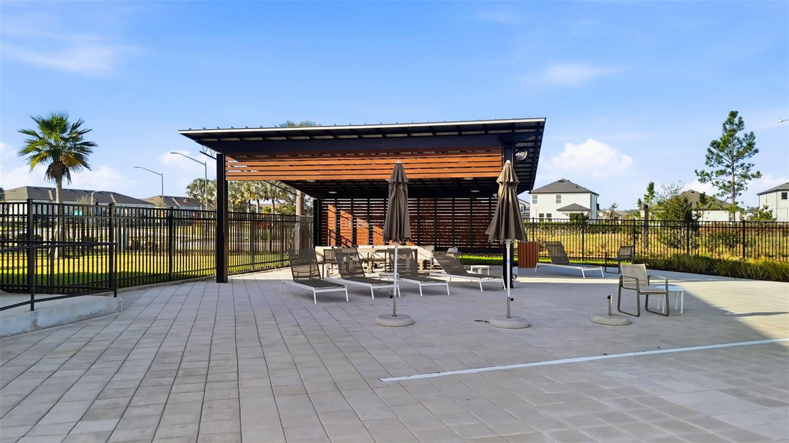 Covered outdoor pavilion with shaded seating, ideal for relaxing poolside or gathering with friends.