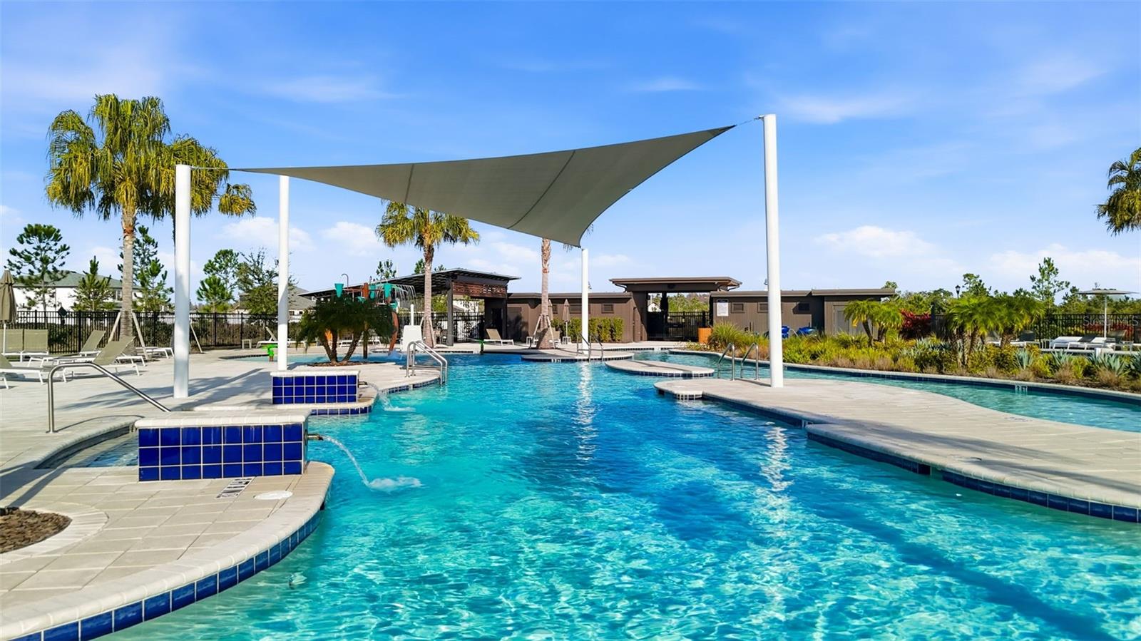 Large swimming pool featuring modern shade structures, wide deck space, and easy walk-in access.