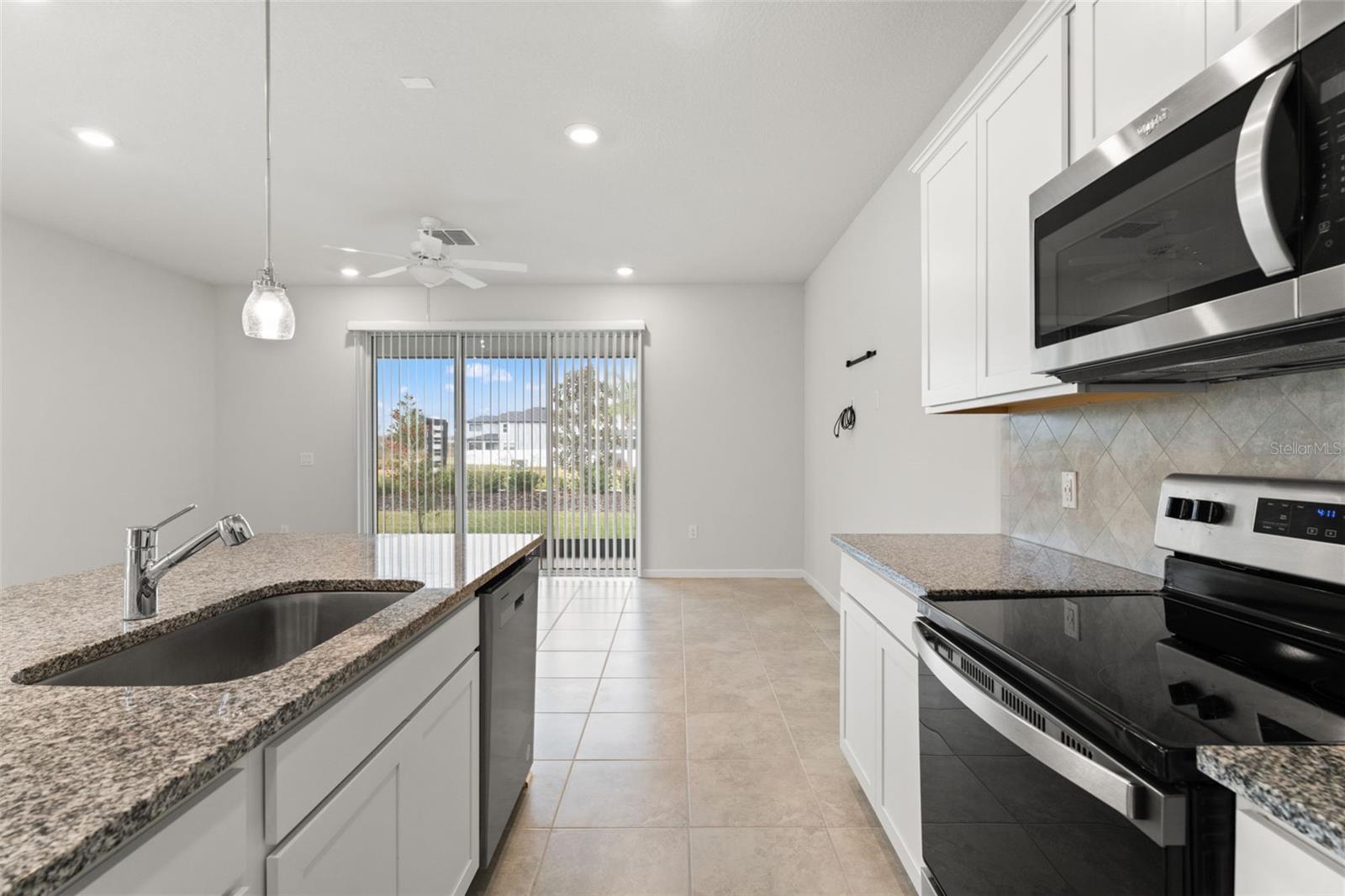 Spacious kitchen layout with a center island, pendant lighting, ample counter space, and modern finishes ideal for everyday functionality.