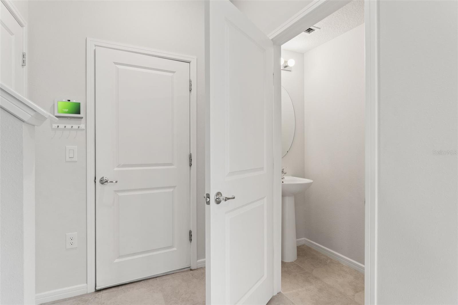 Convenient half bath on the main level with a pedestal sink and clean, modern finishes.