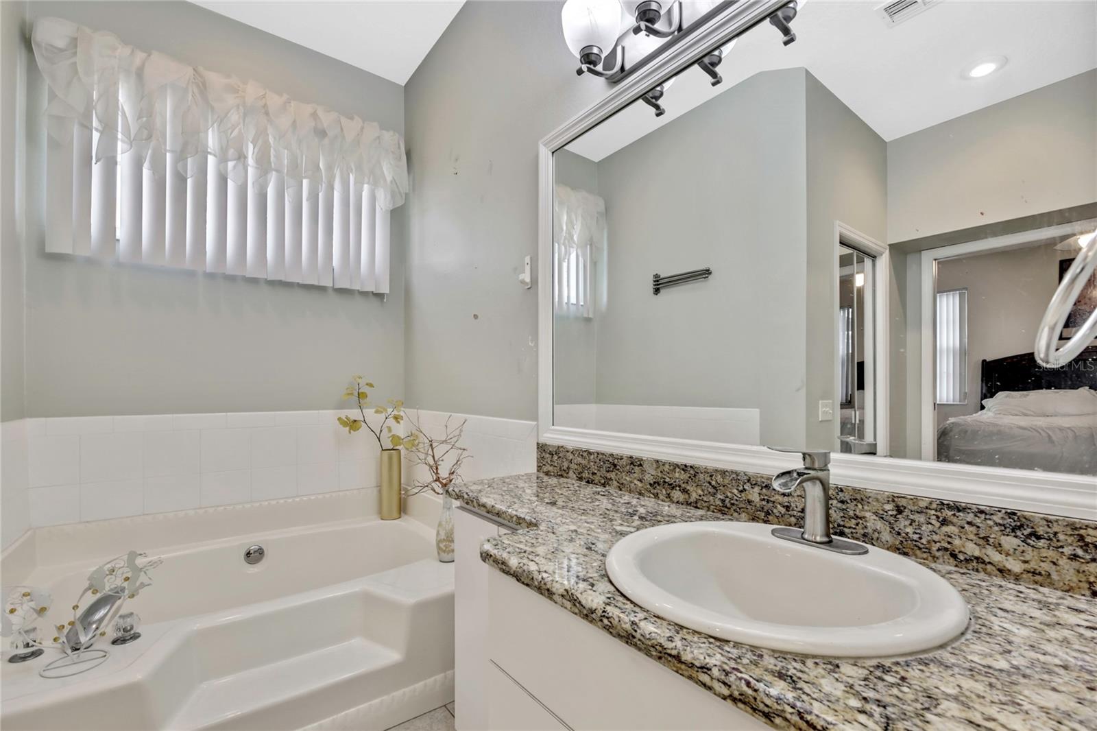 The primary bath also features granite countertops and designer lighting.