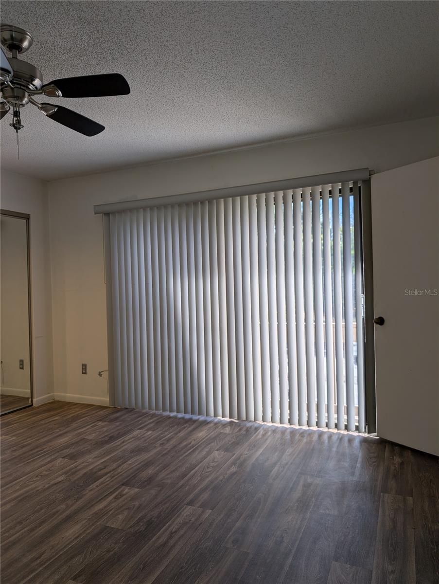 Primary Bedroom with sliding glass doors to small Balcony