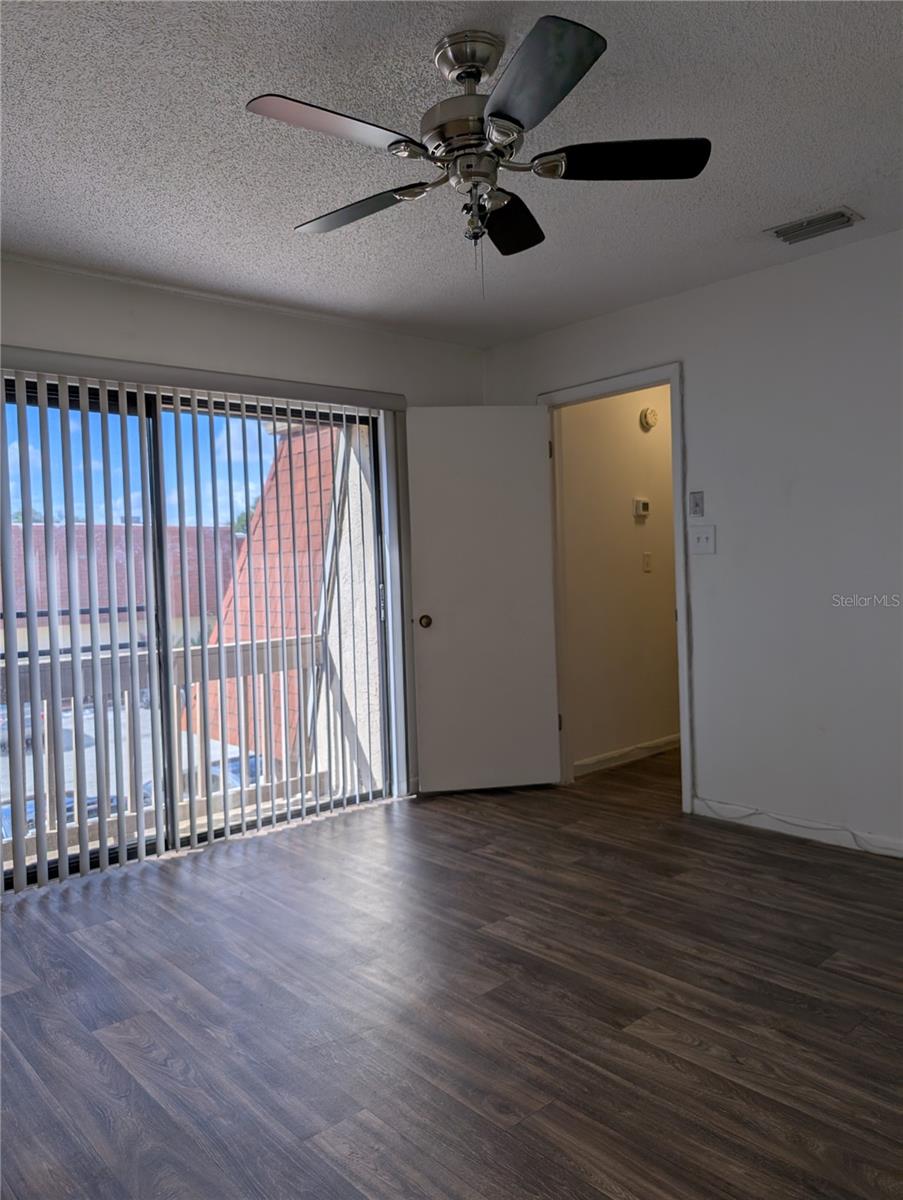 Primary Bedroom with sliding glass doors to small Balcony