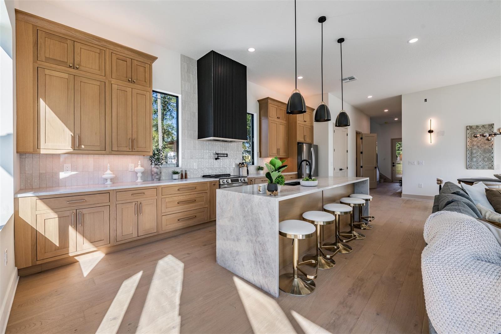 Taj Mahal quartzite waterfall island with under and over cabinet lighting