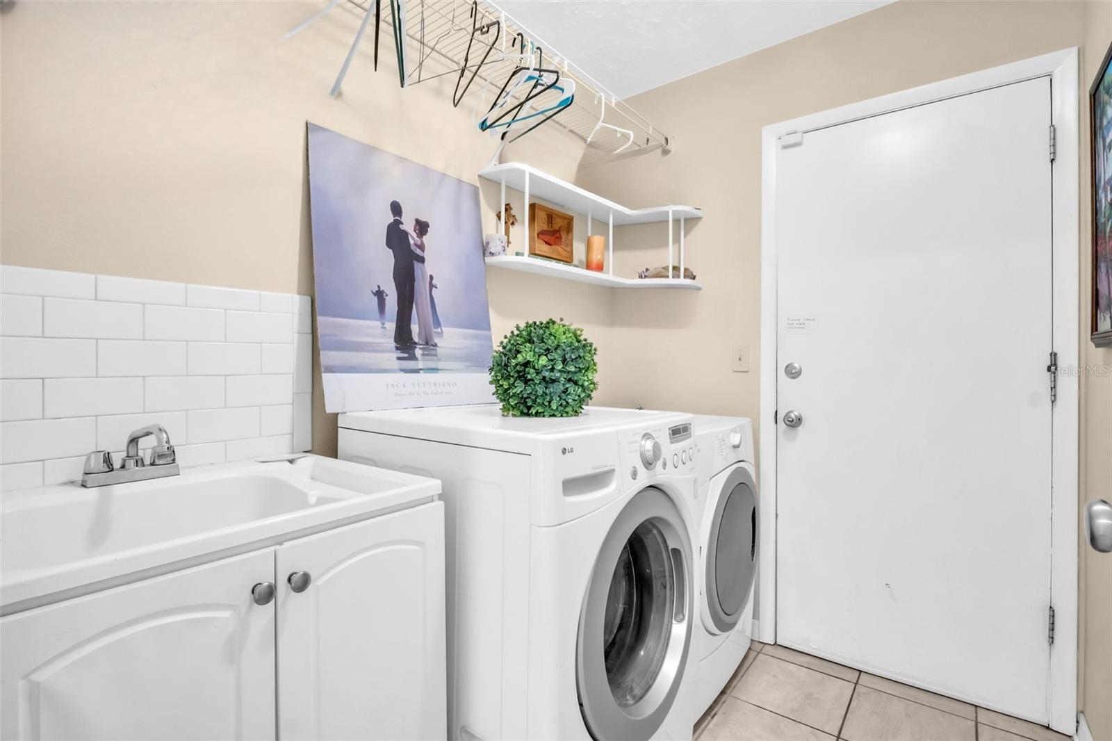 Large laundry room with utility sink between the main living & 2-car garage~