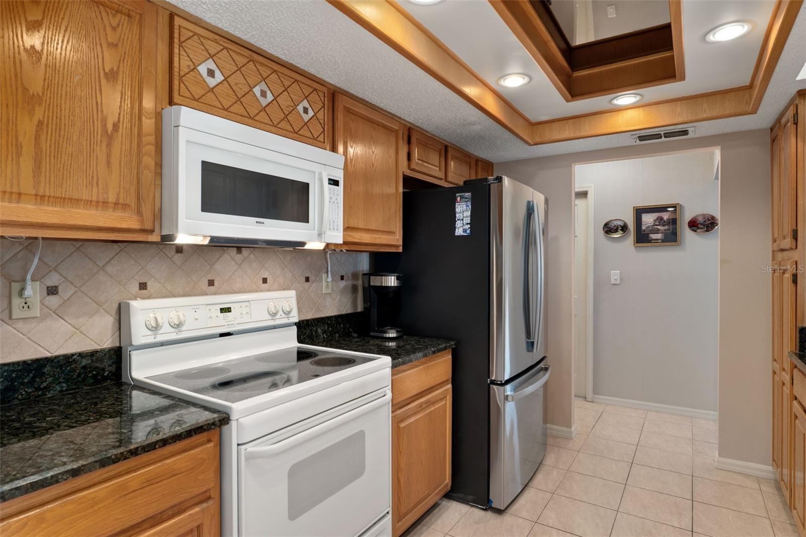 Bosch microwave and Whirlpool convection oven w glass cooktop.  Located just inside from the garage for easy grocery unloading!