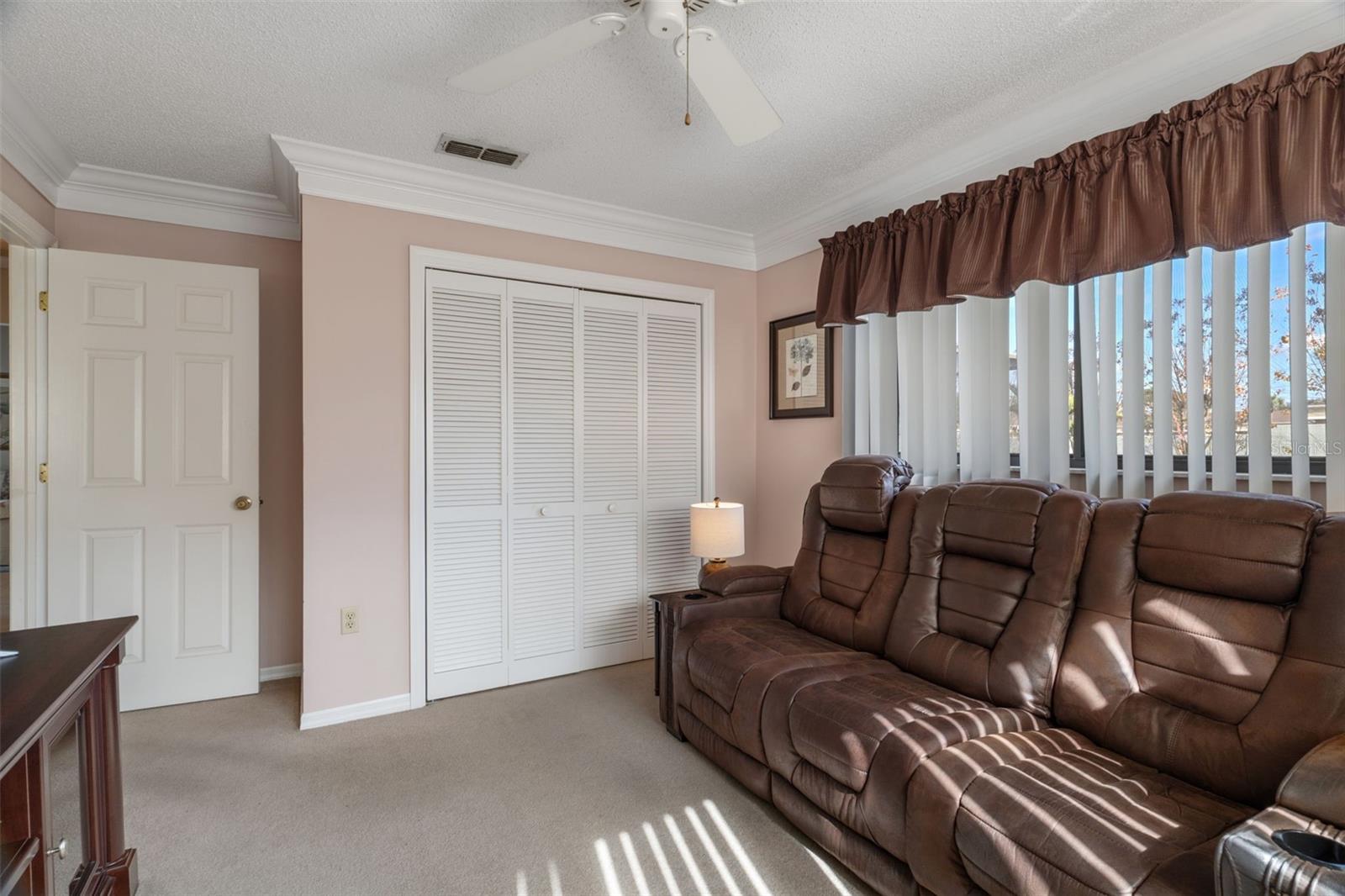 A true 3rd bedroom that also has a spacious closet, crown molding & a ceiling fan.  Furnishings convey.